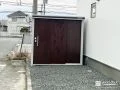シンプルなデザインの物置で雨に濡れない収納空間を設けた工事