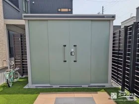 庭の雰囲気に溶け込むやさしいカラー。収納力もしっかり確保した物置[施工後]