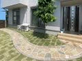 天然石貼り調の玄関アプローチが美しく映えるお庭リフォーム工事