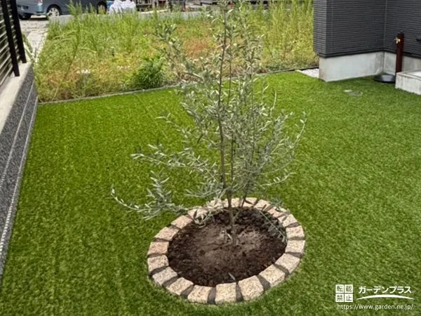 人工芝の中にピンコロ石の植栽スペースが映えるお庭づくり工事