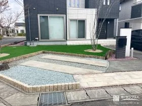 人工芝と石材のコントラストが映える前庭と駐車スペースの工事