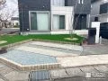 人工芝と石材のコントラストが映える前庭と駐車スペースの工事