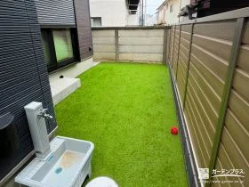 木目調フェンスと人工芝がナチュラルな印象の主庭[施工後]