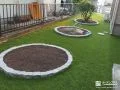 ピンコロ石で植栽スペースを可愛らしく縁取り整えた人工芝のお庭