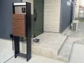 木調の扉がアクセントの宅配ボックス付き機能門柱