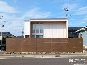 建物の雰囲気に調和する木調フェンスと割栗石がアクセントの工事