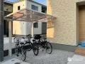 自転車を雨や日差しから守る明るい印象のサイクルポート工事