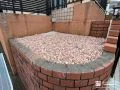 温かみのあるカラーの砂利で雑草対策をした植栽スペース