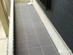 落ち着いたグレーのタイルで上品に雑草対策をした犬走り工事