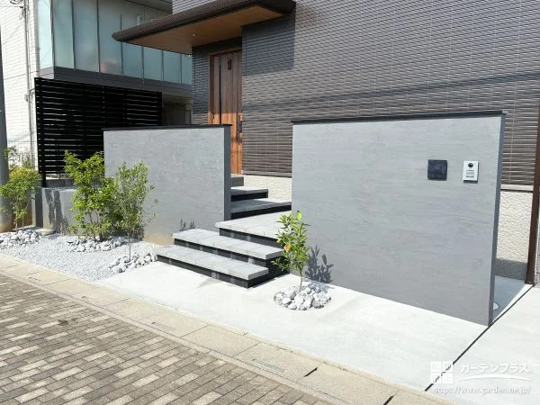 2枚の門柱が住まいを包み込むグレー基調の新築外構