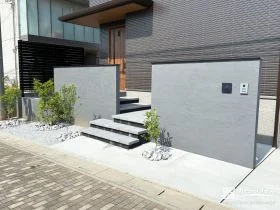 2枚の門柱が住まいを包み込むグレー基調の新築外構