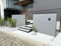 2枚の門柱が住まいを包み込むグレー基調の新築外構