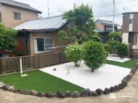 白砂利と人工芝のコントラストが美しい植栽スペースの工事