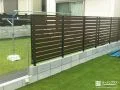 人工芝の緑に映える木目調フェンスで視線をカットした工事
