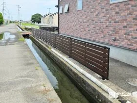 道路や水路に面した高低差のある立地を守る木目調フェンス[施工後]