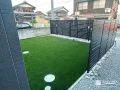 ブラックのフェンスとリアルな人工芝が映える庭