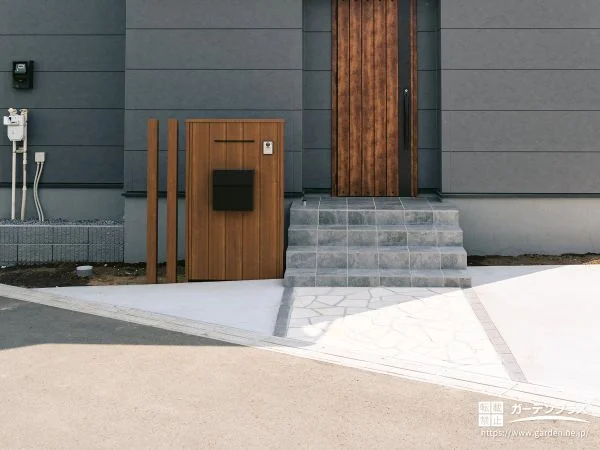 木調の門柱と石張りアプローチが調和する玄関まわり