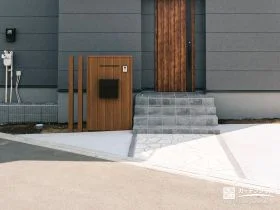 木調の門柱と石張りアプローチが調和する玄関まわり[施工後]