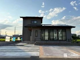 日中は人工芝の緑が外観をやわらかく包み込む駐車スペースデザイン[施工後]