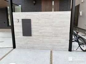 静かな存在感が魅力。重厚感と木目の温もりを併せ持つタイル門柱[施工後]