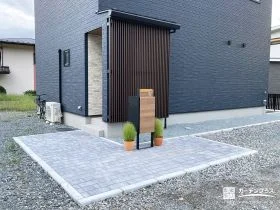 黒の外観を引き立てる温かみを感じるシンプルモダンな新築外構