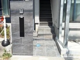 シックなタイル張りの玄関アプローチと造作門柱を施工した工事