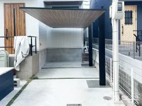 木調の屋根材とブラックフレームがモダンなカーポート設置工事