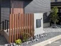 玄関前の目隠しを兼ねる門柱とスリットフェンス