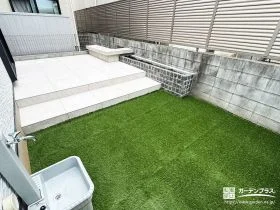 「白いタイルデッキが映える、手入れしやすい人工芝の庭[施工後]
