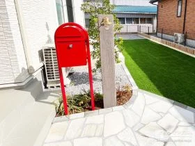 赤いポストが映える、ナチュラルで上品な石張りアプローチ[施工後]