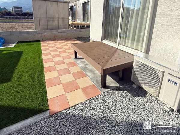 オレンジのインターロッキングと緑の人工芝が鮮やかなお庭工事