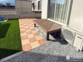 オレンジのインターロッキングと緑の人工芝が鮮やかなお庭工事