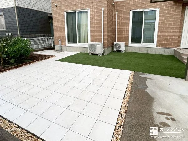 タイルの駐車スペースと人工芝のお庭のコントラストが美しい工事
