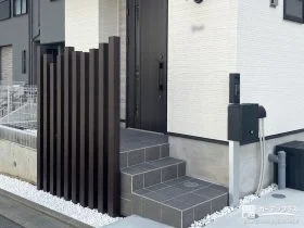 玄関前を縦ラインが美しい枕木材で引き締め目隠しをした工事