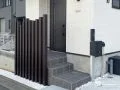 玄関前を縦ラインが美しい枕木材で引き締め目隠しをした工事