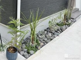黒い割栗石と植栽で犬走りをスタイリッシュに彩るリフォーム工事