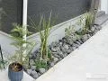 黒い割栗石と植栽で犬走りをスタイリッシュに彩るリフォーム工事