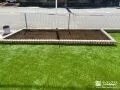 レンガの花壇が可愛らしいアクセントになった人工芝のお庭工事