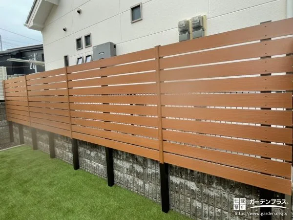 横板デザインの木調目隠しフェンスと人工芝で整えたお庭工事