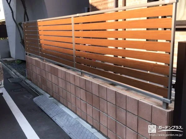 優しい風合いの化粧ブロックに木目調フェンスを設置した工事