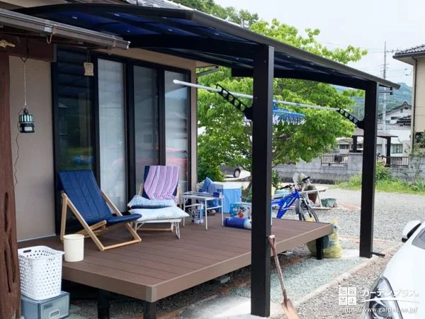 屋根付きのウッドデッキと鮮やかなブルーの物置を設置した工事