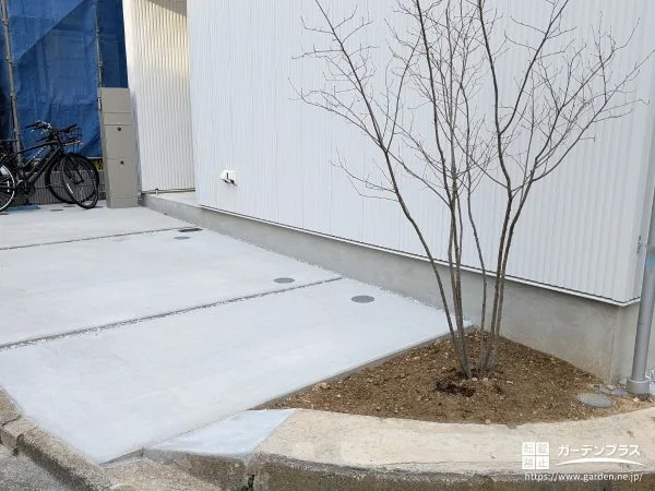 すっきりデザインの駐車スペースに植栽がアクセントを加える工事