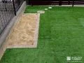 レンガの花壇がアクセントになった人工芝敷きのお庭