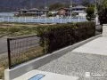 ダークカラーが景観になじむメッシュフェンスを設置した工事