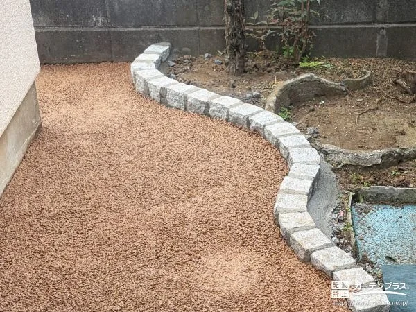 曲線を描くデザインの花壇が優しい印象を演出するお庭工事