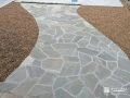 曲線が迎える石張りの玄関アプローチ