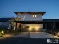 建物や植栽を優しい光で照らした夜の外構