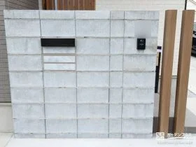 目隠しを兼ねた造作門柱と木調の角柱が玄関前を彩る外構工事