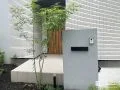 グレーの門柱と植栽が調和するスタイリッシュな新築外構工事