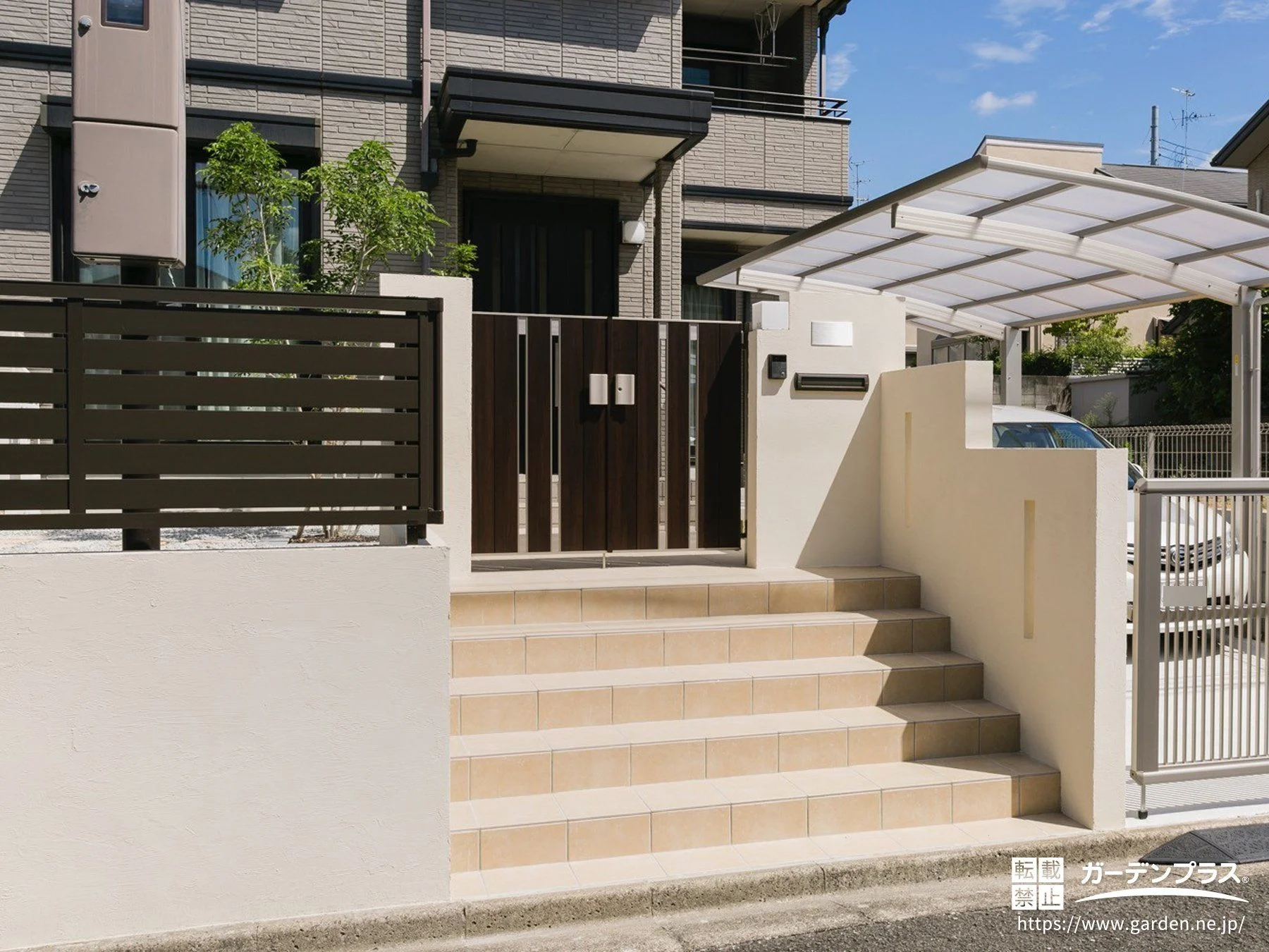 白い塗り壁と木目調の門扉やフェンスの調和がきれいなリフォーム